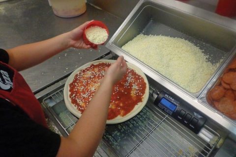 Нанесение сыра на пиццу